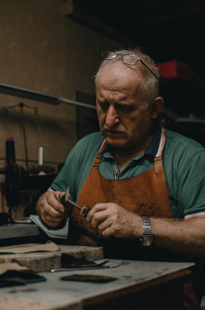 pexels-photo-3084343-3084343 Portrait of a senior artisan crafting in his workshop with focused precision.