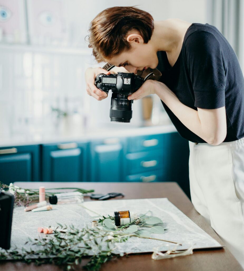 pexels-photo-3584951-3584951 Woman taking photos of a still life setup with camera in a modern indoor setting.
