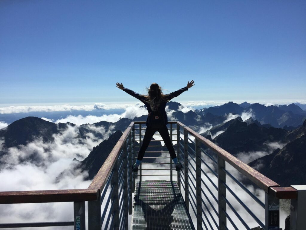 pexels-photo-725255-725255 A woman stands on a viewing platform in Vysoké Tatry, Slovakia, surrounded by clouds and mountains, embracing freedom.