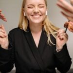 Happy woman smiling with closed eyes and earpods in a business meeting.