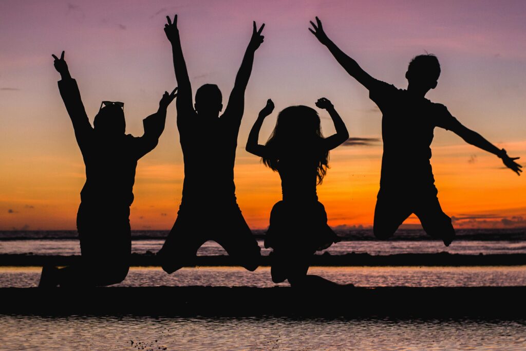 pexels-photo-935835-935835 Silhouette of friends jumping on the beach at sunset, celebrating summer fun.
